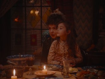 Movie still from “The Electrical Life of Louis Wain” (2021), directed by Will Sharpe – A woman and a child sitting at a table with candles; Close Up shot, Over the shoulder angle