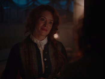 Movie still from “The Electrical Life of Louis Wain” (2021), directed by Will Sharpe – A woman with red curly hair is looking at the camera; Close Up shot, Over the shoulder angle