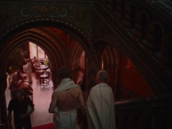 Movie still from “The Electrical Life of Louis Wain” (2021), directed by Will Sharpe – Two men are standing in a doorway of a restaurant; Wide shot, Over the shoulder angle