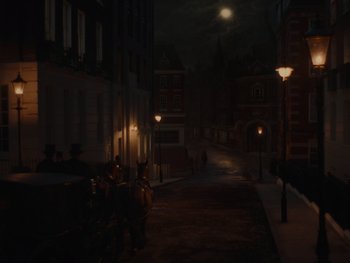 Movie still from “The Electrical Life of Louis Wain” (2021), directed by Will Sharpe – Two people sitting on a bench in the dark near a street light; Extreme Wide shot, High angle