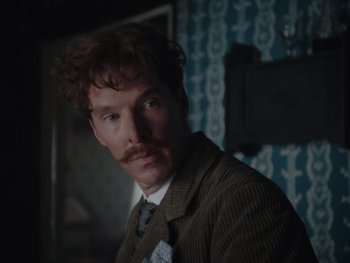 Movie still from “The Electrical Life of Louis Wain” (2021), directed by Will Sharpe – A man in a suit and tie with a mustache; Close Up shot, Over the shoulder angle
