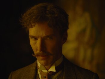 Movie still from “The Electrical Life of Louis Wain” (2021), directed by Will Sharpe – A man in a suit and tie with a mustache; Close Up shot, Over the shoulder angle