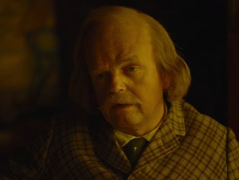 Movie still from “The Electrical Life of Louis Wain” (2021), directed by Will Sharpe – An old man with a long hair and a beard; Close Up shot, Over the shoulder angle