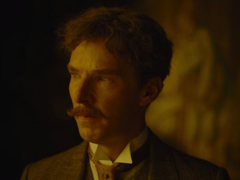 Movie still from “The Electrical Life of Louis Wain” (2021), directed by Will Sharpe – A person wearing a suit and tie; Close Up shot, Over the shoulder angle