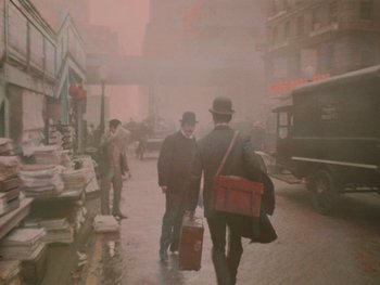Movie still from “The Electrical Life of Louis Wain” (2021), directed by Will Sharpe – Two men walking down the street in the fog; Wide shot, High angle