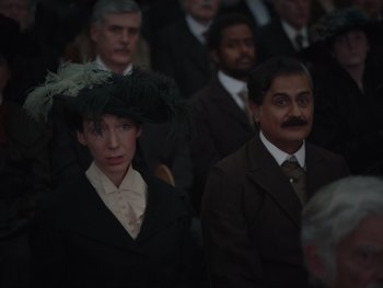 Movie still from “The Electrical Life of Louis Wain” (2021), directed by Will Sharpe – A group of men and women in suits and hats; Medium shot, High angle