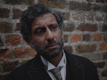 Movie still from “The Electrical Life of Louis Wain” (2021), directed by Will Sharpe – A man in a suit and a tie; Close Up shot, High angle