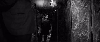 Movie still from “The Elephant Man” (1980), directed by David Lynch – A man wearing a top hat walking down a dark hallway; Medium shot, Low angle