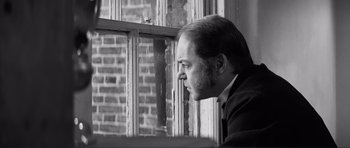 Movie still from “The Elephant Man” (1980), directed by David Lynch – Black and white photograph of a man looking out of a window; Close Up shot, Low angle