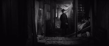 Movie still from “The Elephant Man” (1980), directed by David Lynch – A man wearing a top hat in an abandoned building; Wide shot, Low angle
