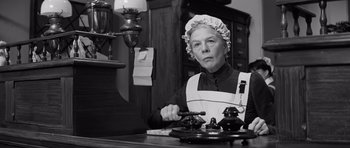 Movie still from “The Elephant Man” (1980), directed by David Lynch – An older woman in an old - fashioned kitchen setting; Medium shot, Low angle