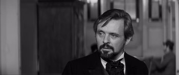 Movie still from “The Elephant Man” (1980), directed by David Lynch – Black and white photograph of a man in a suit and tie; Close Up shot, Over the shoulder angle