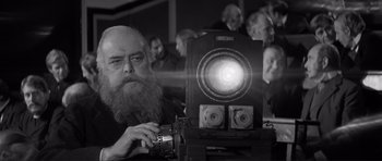 Movie still from “The Elephant Man” (1980), directed by David Lynch – An old man with a beard is holding an old camera; Close Up shot, Low angle