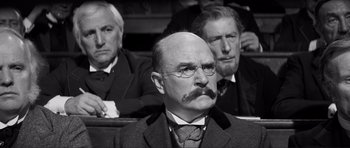 Movie still from “The Elephant Man” (1980), directed by David Lynch – A man in a suit and tie with a mustache; Close Up shot, Low angle