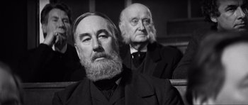 Movie still from “The Elephant Man” (1980), directed by David Lynch – A man with a long beard sitting next to another man with a long beard; Close Up shot, Low angle