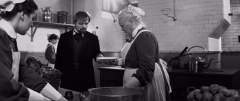 Movie still from “The Elephant Man” (1980), directed by David Lynch – An older woman and a young man in a kitchen; Medium shot, Over the shoulder angle
