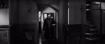 Movie still from “The Elephant Man” (1980), directed by David Lynch – A black and white photo of a man walking in a hallway; Medium shot, Low angle