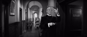 Movie still from “The Elephant Man” (1980), directed by David Lynch – An older man in a suit is holding his hand up; Medium shot, Low angle