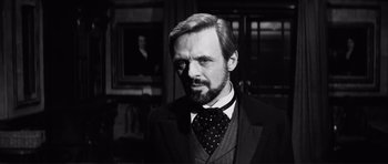 Movie still from “The Elephant Man” (1980), directed by David Lynch – Black and white photograph of a man wearing a suit and tie; Close Up shot, Over the shoulder angle