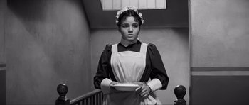 Movie still from “The Elephant Man” (1980), directed by David Lynch – A woman in a maid's outfit holding a plate; Medium shot, High angle