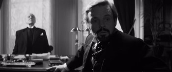 Movie still from “The Elephant Man” (1980), directed by David Lynch – A black and white photo of a man in a suit and tie; Close Up shot, Over the shoulder angle