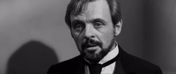 Movie still from “The Elephant Man” (1980), directed by David Lynch – Black and white photograph of a man in a suit and tie; Close Up shot, Over the shoulder angle