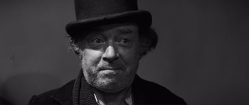 Movie still from “The Elephant Man” (1980), directed by David Lynch – A black and white photo of a man wearing a top hat; Close Up shot, Low angle