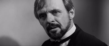 Movie still from “The Elephant Man” (1980), directed by David Lynch – Black and white photograph of a man with a beard; Close Up shot, Over the shoulder angle