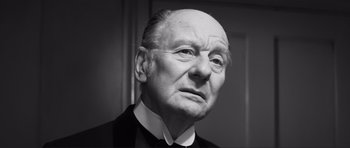 Movie still from “The Elephant Man” (1980), directed by David Lynch – An old man with a bald head wearing a suit and tie; Close Up shot, Low angle