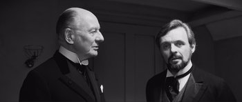 Movie still from “The Elephant Man” (1980), directed by David Lynch – Two men standing next to each other in a room; Close Up shot, Over the shoulder angle