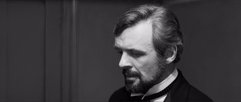 Movie still from “The Elephant Man” (1980), directed by David Lynch – Black and white photograph of a man with a beard looking to his left; Close Up shot, Over the shoulder angle