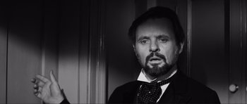 Movie still from “The Elephant Man” (1980), directed by David Lynch – A black and white photo of a man with a beard; Close Up shot, Over the shoulder angle