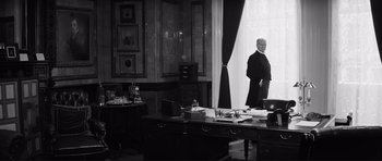 Movie still from “The Elephant Man” (1980), directed by David Lynch – A man standing in front of a window in a room; Wide shot, Low angle