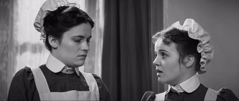 Movie still from “The Elephant Man” (1980), directed by David Lynch – Two young women are standing next to each other; Close Up shot, Low angle