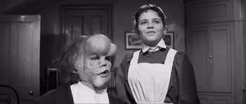 Movie still from “The Elephant Man” (1980), directed by David Lynch – A woman and a man in costume in a room; Close Up shot, Low angle