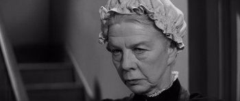 Movie still from “The Elephant Man” (1980), directed by David Lynch – An older woman wearing a hat and looking sad; Close Up shot, Low angle