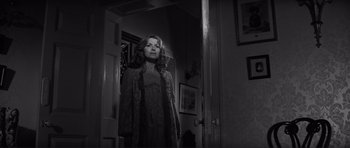 Movie still from “The Elephant Man” (1980), directed by David Lynch – A black and white photo of a woman standing in front of a mirror; Medium shot, Low angle