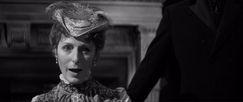 Movie still from “The Elephant Man” (1980), directed by David Lynch – An older woman wearing a hat and a dress; Close Up shot, Over the shoulder angle