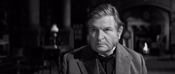 Movie still from “The Elephant Man” (1980), directed by David Lynch – An older man in a suit and a tie; Close Up shot, Over the shoulder angle