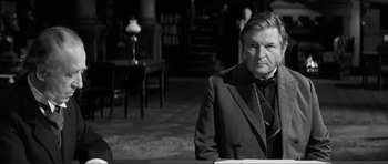 Movie still from “The Elephant Man” (1980), directed by David Lynch – An older man wearing a suit and a tie; Medium shot, Over the shoulder angle
