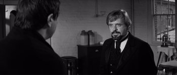 Movie still from “The Elephant Man” (1980), directed by David Lynch – A man in a suit and tie talking to another man in a suit and tie; Close Up shot, Over the shoulder angle