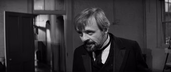 Movie still from “The Elephant Man” (1980), directed by David Lynch – Black and white photograph of a man wearing a suit and tie; Close Up shot, Over the shoulder angle