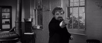 Movie still from “The Elephant Man” (1980), directed by David Lynch – A black and white photo of a man pointing at the camera; Medium shot, Over the shoulder angle