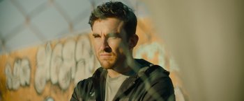 Movie still from “The Enforcer” (2022), directed by Richard Hughes – A person wearing a black jacket; Close Up shot, Low angle