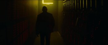 Movie still from “The Enforcer” (2022), directed by Richard Hughes – A man is walking in a dark hallway; Wide shot, Low angle