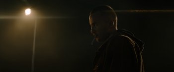 Movie still from “The Enforcer” (2022), directed by Richard Hughes – A man with a cigarette in his mouth in the dark; Close Up shot, Low angle