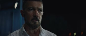 Movie still from “The Enforcer” (2022), directed by Richard Hughes – A person wearing a white shirt; Close Up shot, Over the shoulder angle