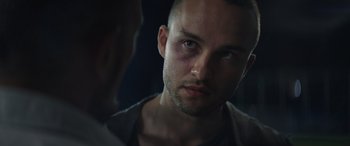 Movie still from “The Enforcer” (2022), directed by Richard Hughes – A person with a bruise on his face; Close Up shot, Over the shoulder angle