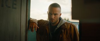 Movie still from “The Enforcer” (2022), directed by Richard Hughes – A person leaning on a wall; Close Up shot, Low angle