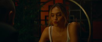 Movie still from “The Enforcer” (2022), directed by Richard Hughes – A beautiful young lady sitting in front of a building; Close Up shot, Over the shoulder angle